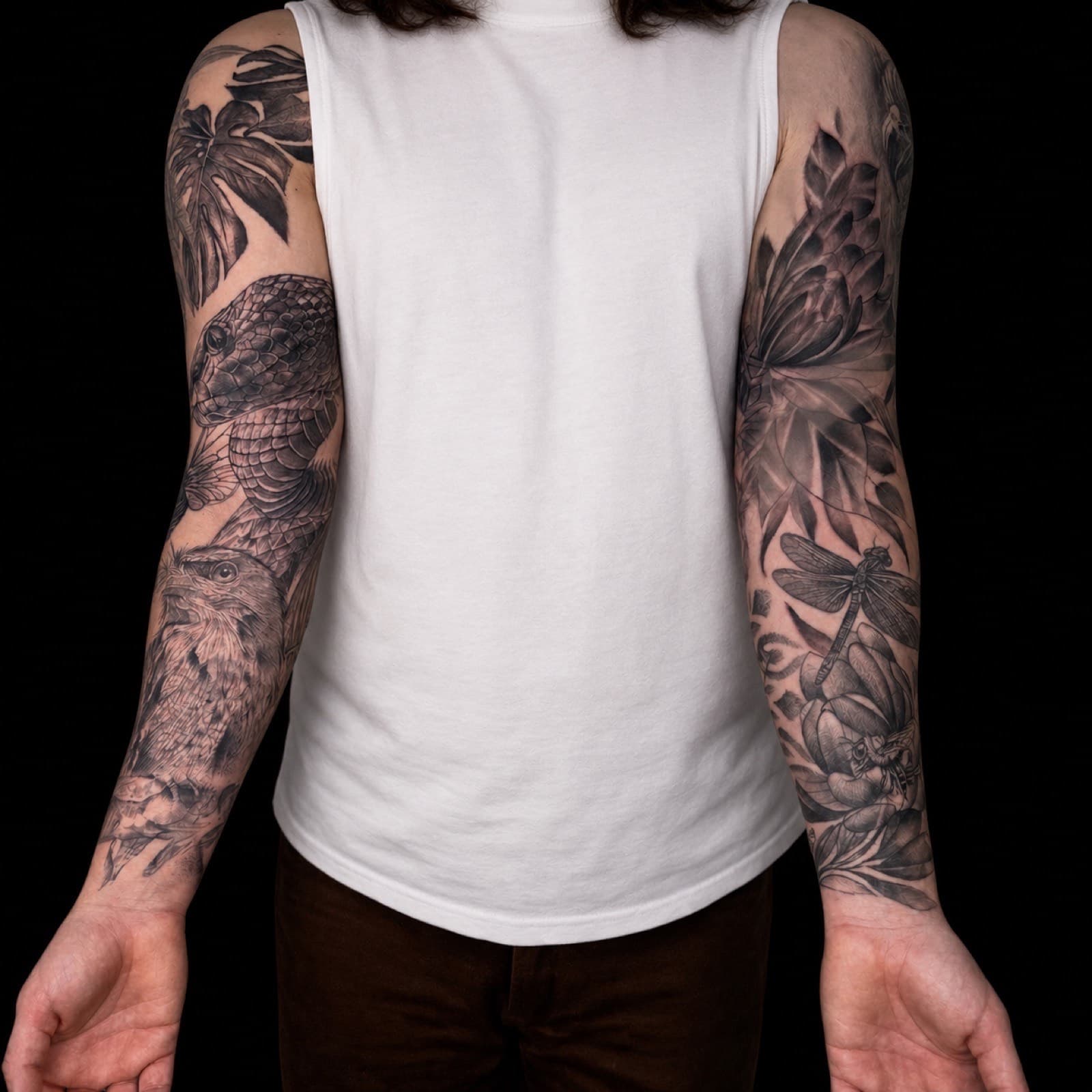 Matching botanical and animal black and grey sleeve tattoos by Tobias Meredith