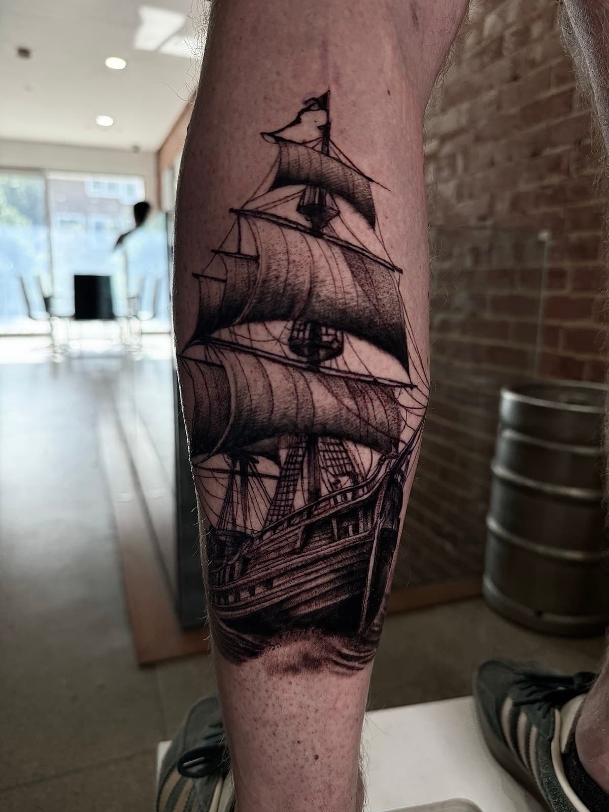 Realistic black and grey sailing ship calf tattoo by Tobias Meredith