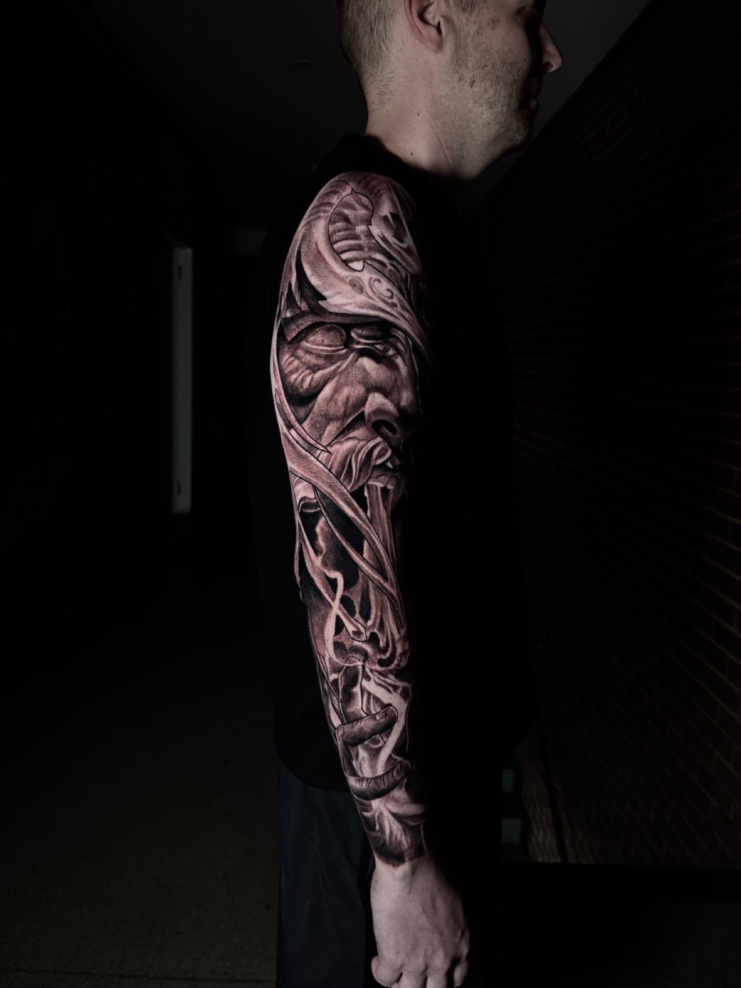 Black and grey realism sleeve tattoo by Tobias Meredith