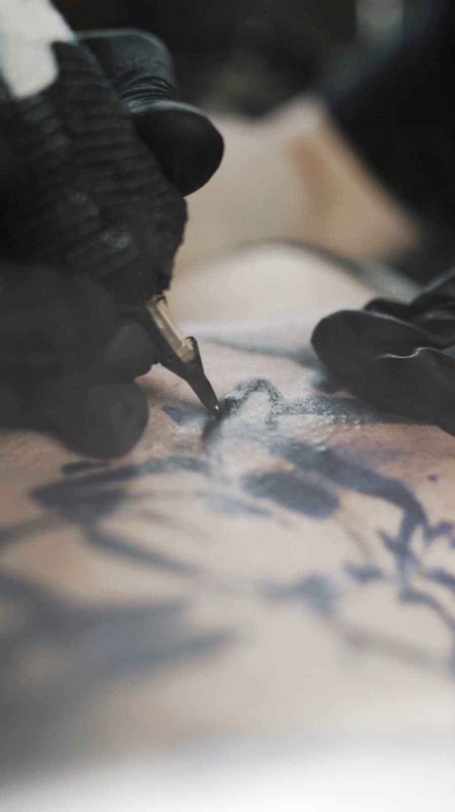 Tattoo session in progress — close-up of machine and ink